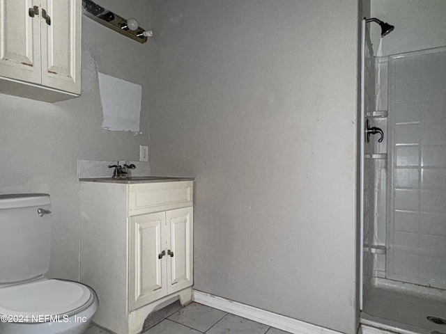 bathroom with tile patterned flooring, vanity, toilet, and walk in shower