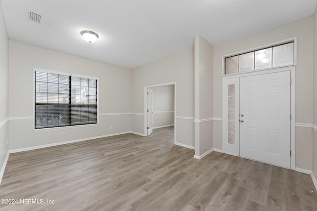 entryway featuring a textured ceiling and light hardwood / wood-style flooring