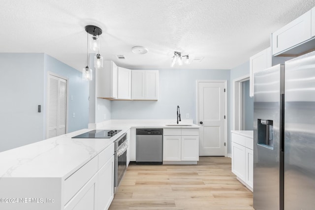 kitchen featuring white cabinets, stainless steel appliances, kitchen peninsula, and sink