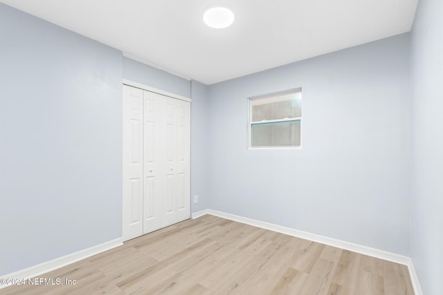 unfurnished bedroom featuring a closet and light hardwood / wood-style flooring