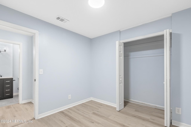 unfurnished bedroom featuring a closet and light wood-type flooring