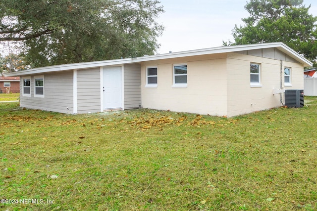 back of house with a lawn and cooling unit