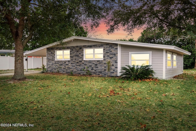 property exterior at dusk with a lawn