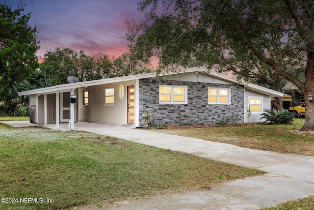 view of front of property with a lawn and a carport