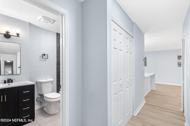 bathroom with hardwood / wood-style flooring, vanity, and toilet