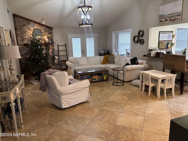 living room featuring an inviting chandelier, french doors, and vaulted ceiling