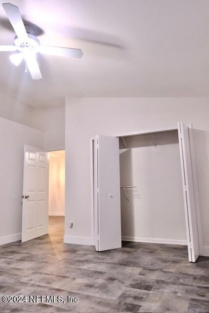 unfurnished bedroom with ceiling fan, a closet, and lofted ceiling