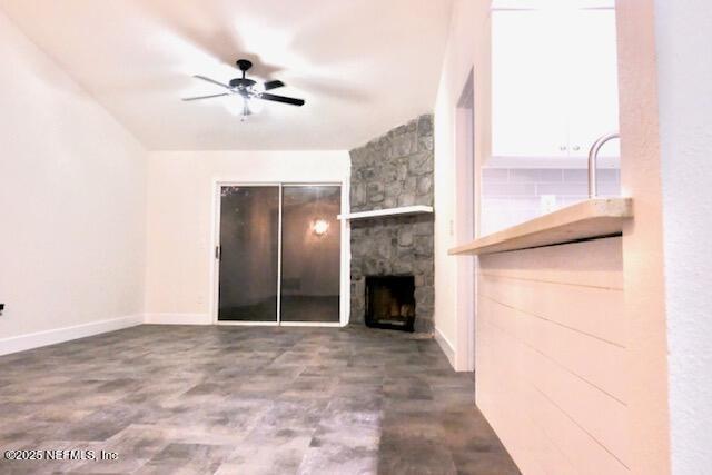 unfurnished living room with a fireplace and ceiling fan