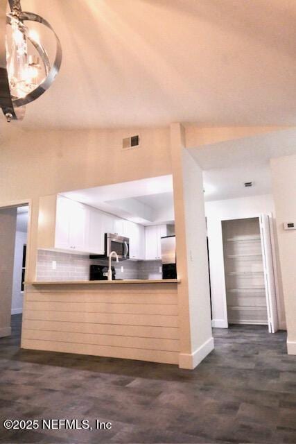 kitchen with tasteful backsplash, sink, white cabinets, and stainless steel appliances