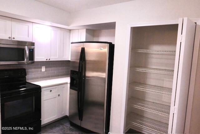 kitchen with white cabinets, appliances with stainless steel finishes, and tasteful backsplash