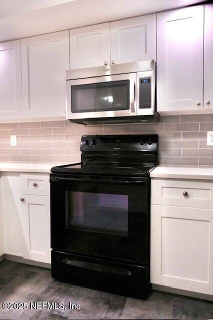 kitchen with backsplash, white cabinetry, and black range with electric cooktop