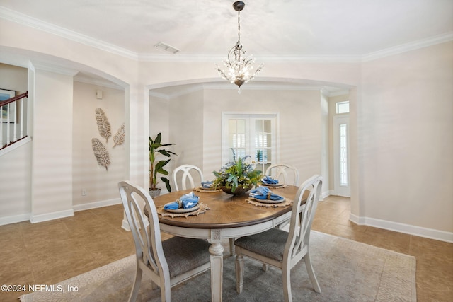 tiled dining room featuring an inviting chandelier and ornamental molding