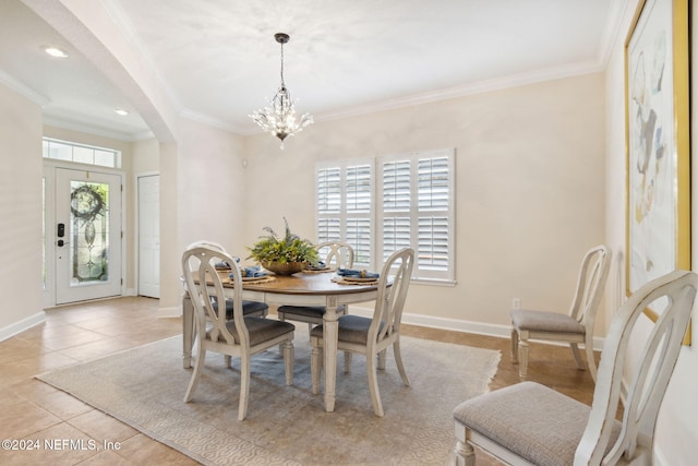 dining room with a wealth of natural light, light tile patterned flooring, crown molding, and a chandelier