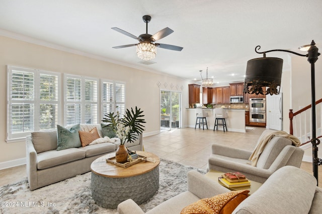 living room featuring ceiling fan with notable chandelier, light tile patterned floors, and crown molding