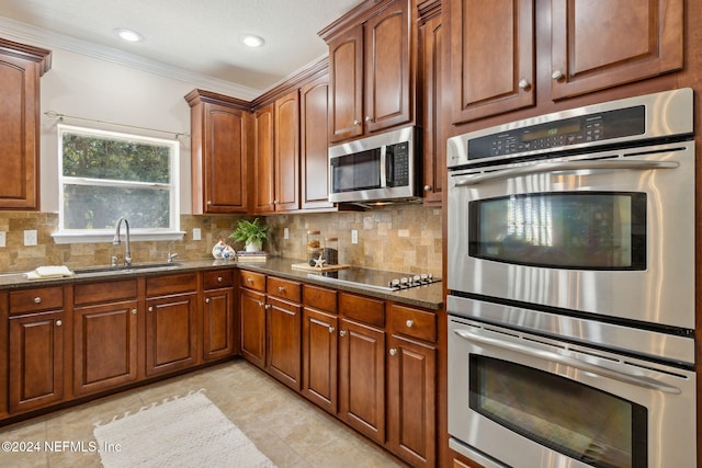 kitchen with tasteful backsplash, sink, appliances with stainless steel finishes, and dark stone counters