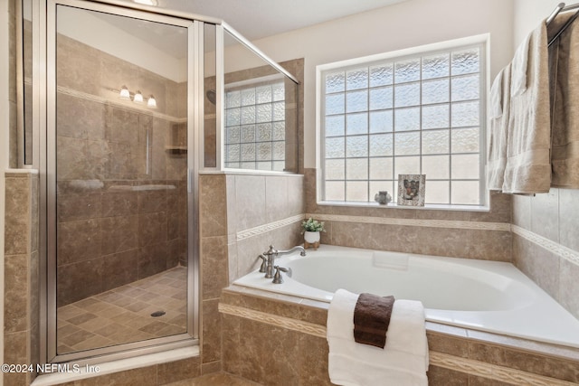 bathroom featuring shower with separate bathtub