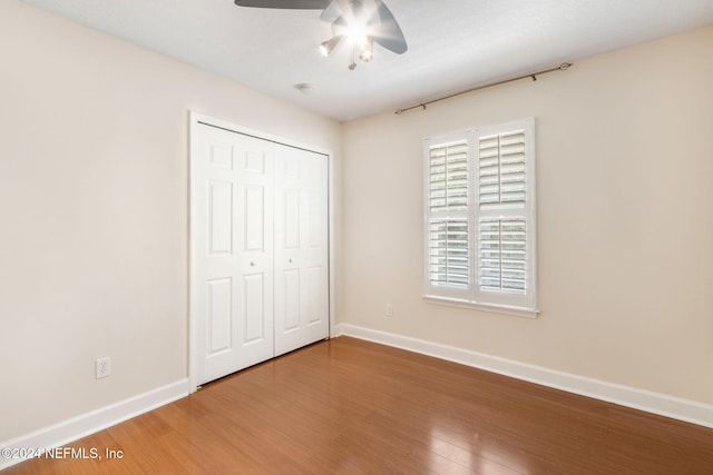 unfurnished bedroom featuring ceiling fan, a closet, and hardwood / wood-style flooring