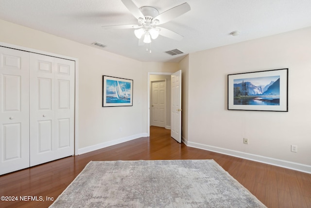 bedroom featuring ceiling fan, a closet, and dark hardwood / wood-style flooring