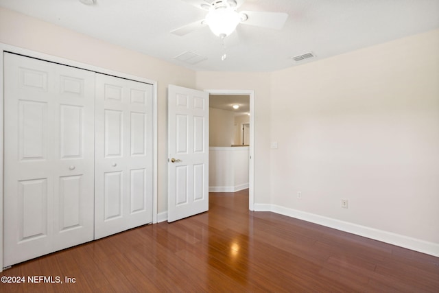 unfurnished bedroom featuring ceiling fan, a closet, and dark hardwood / wood-style floors