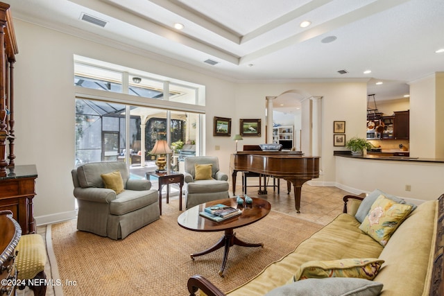 living room with a raised ceiling, decorative columns, crown molding, a towering ceiling, and light tile patterned floors