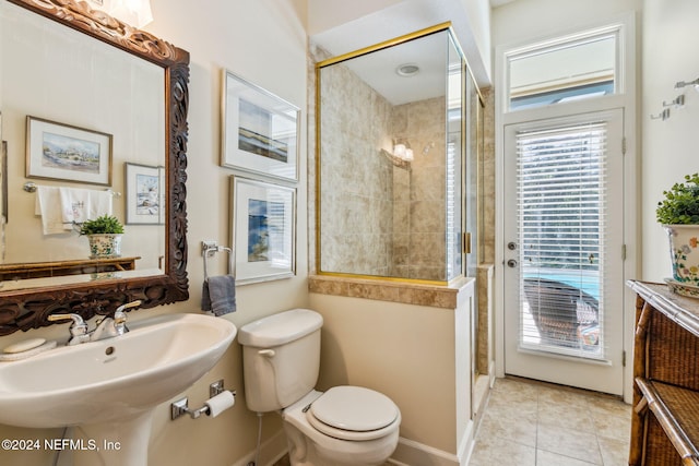 bathroom featuring tile patterned flooring, toilet, walk in shower, and sink