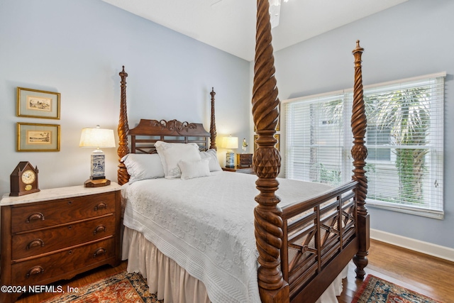 bedroom with hardwood / wood-style floors and lofted ceiling