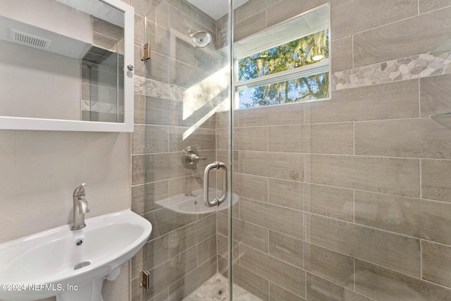 bathroom featuring an enclosed shower and sink