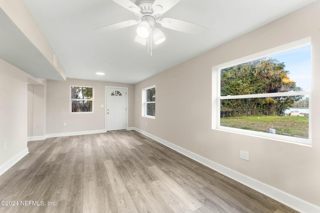 unfurnished room with light hardwood / wood-style flooring, a wealth of natural light, and ceiling fan