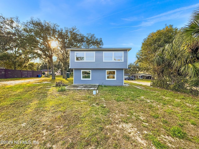 rear view of house featuring a lawn and a patio area