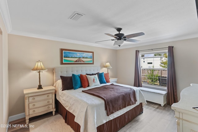 bedroom featuring hardwood / wood-style flooring, ceiling fan, and crown molding