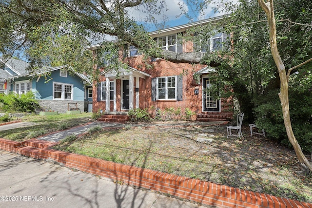 colonial house featuring brick siding