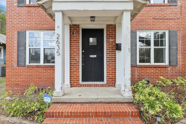 view of exterior entry featuring brick siding