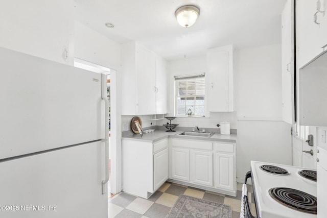 kitchen featuring white appliances, white cabinetry, a sink, and light floors