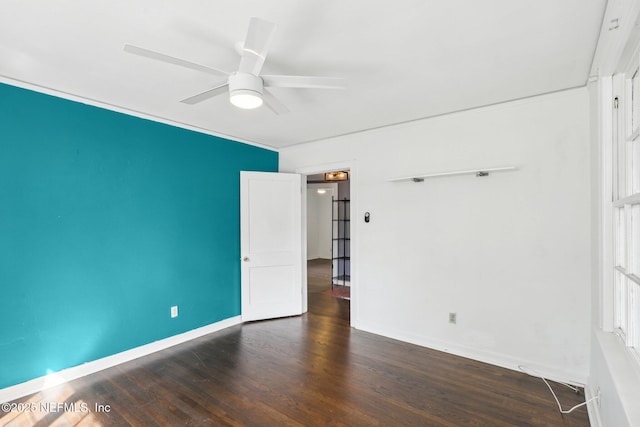 unfurnished room with dark wood-type flooring, ceiling fan, and baseboards