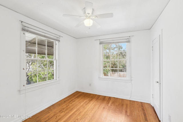 empty room featuring a ceiling fan, light wood-type flooring, and baseboards