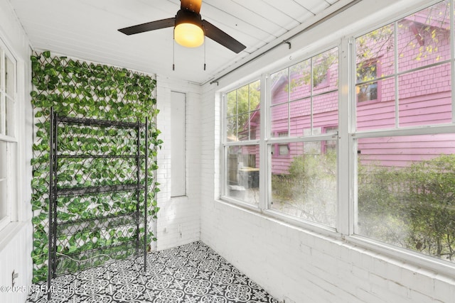 unfurnished sunroom with a ceiling fan