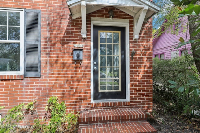 view of exterior entry featuring brick siding