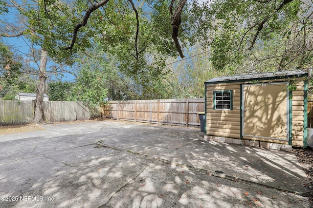 exterior space with a fenced backyard, an outdoor structure, and a shed