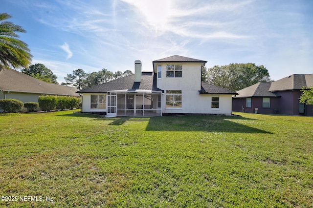 back of property featuring a sunroom and a lawn