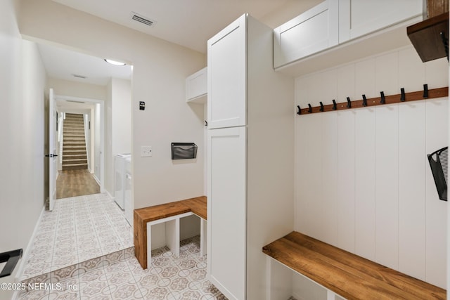 mudroom with light tile patterned flooring and washing machine and dryer