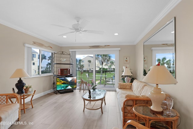 living room with ceiling fan, light wood-type flooring, and ornamental molding