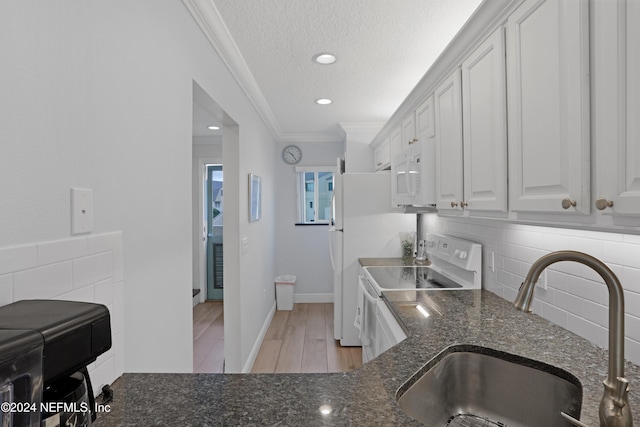 kitchen with white appliances, sink, ornamental molding, a textured ceiling, and white cabinetry