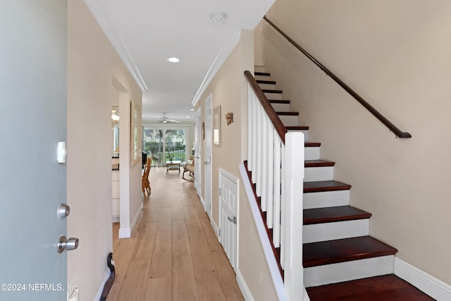 hall with light hardwood / wood-style floors and ornamental molding