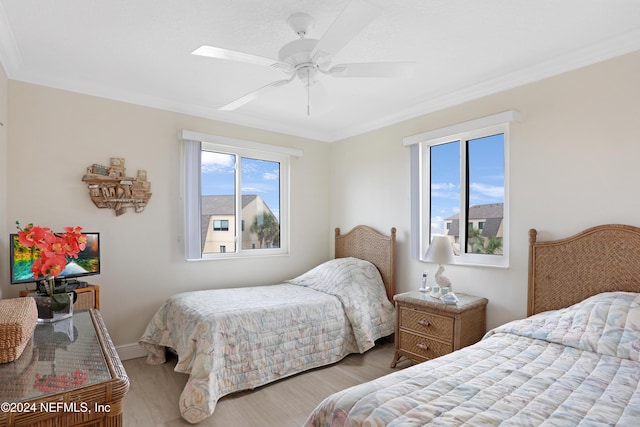 bedroom with hardwood / wood-style floors, ceiling fan, and ornamental molding