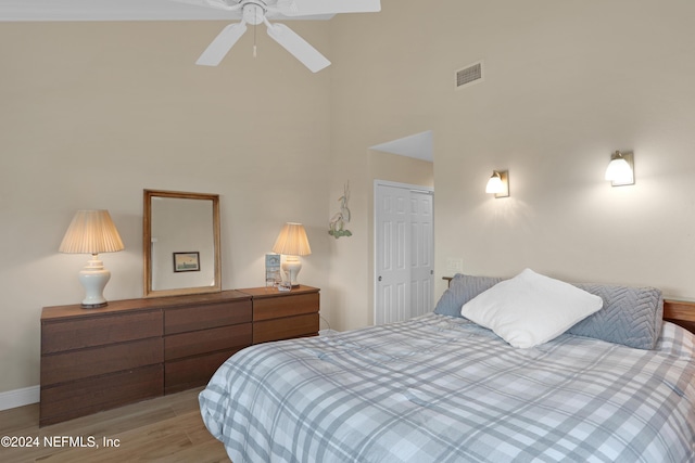 bedroom featuring ceiling fan, light hardwood / wood-style floors, and a closet