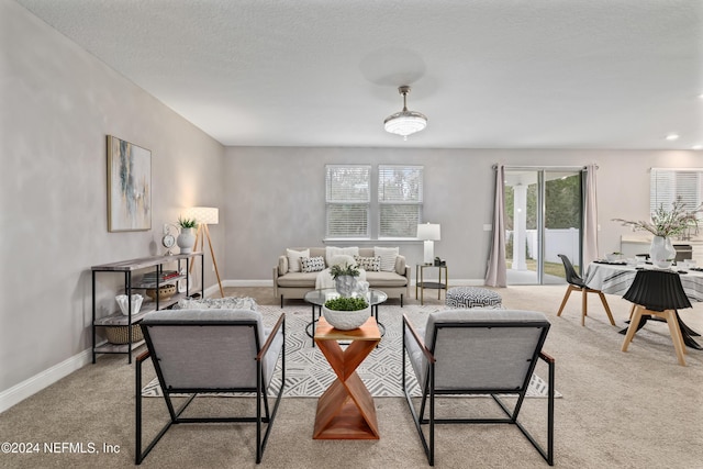 living room featuring light colored carpet and a textured ceiling