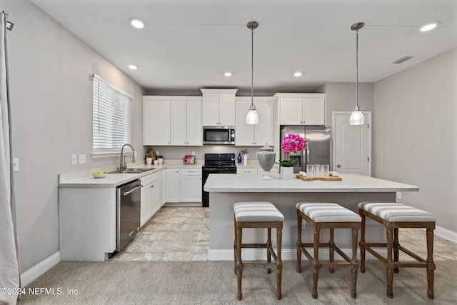 kitchen featuring sink, a kitchen island, decorative light fixtures, and appliances with stainless steel finishes