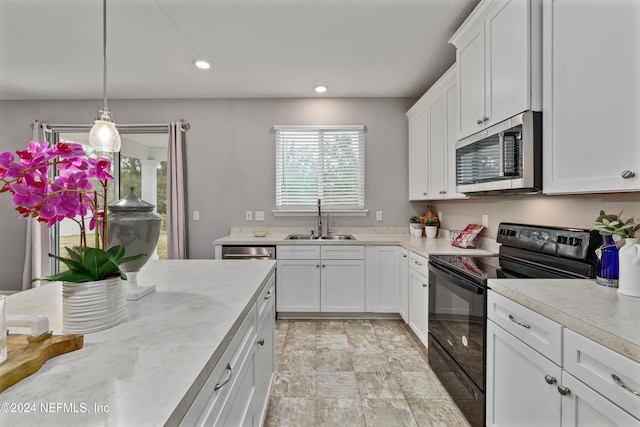 kitchen with white cabinets, decorative light fixtures, sink, and black electric range