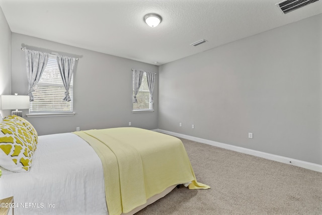 carpeted bedroom featuring a textured ceiling