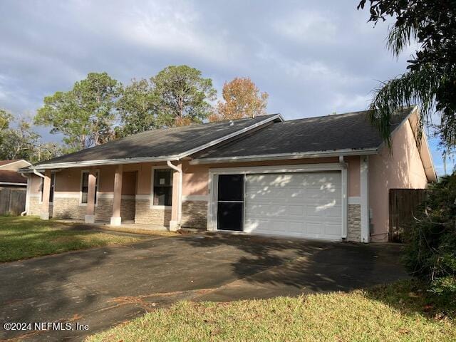 ranch-style house with covered porch, a garage, and a front yard